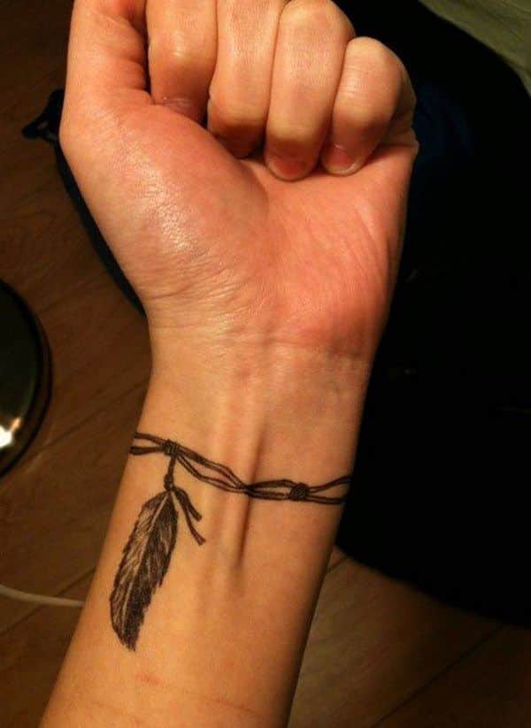 pluma tatuada en la muñeca