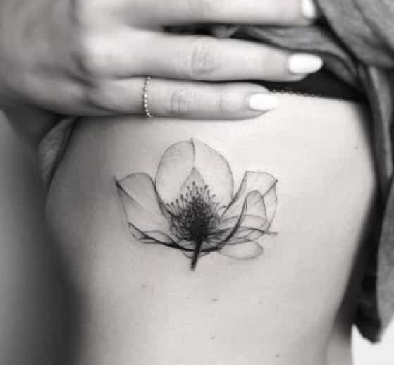 flor en negro a un costado tattoo